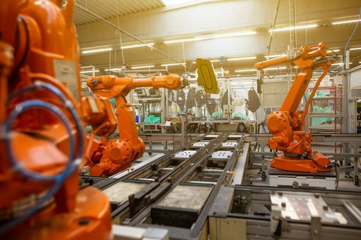 Automatisierte Roboterarme in einer Fabrikhalle